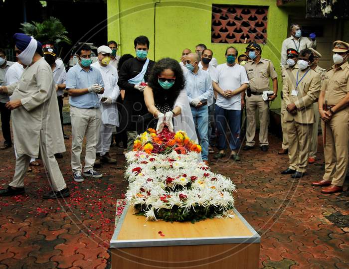 Wife of deceased Air India pilot Deepak Sathe places flowers on his coffin during his funeral in Mumbai, India on August 11, 2020.