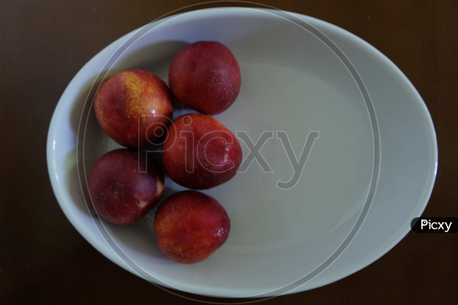 Peaches in an oval white tray.