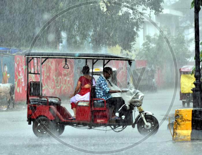 A man drives e-rickshaw on the road during heavy rains in Prayagraj, August 12, 2020.