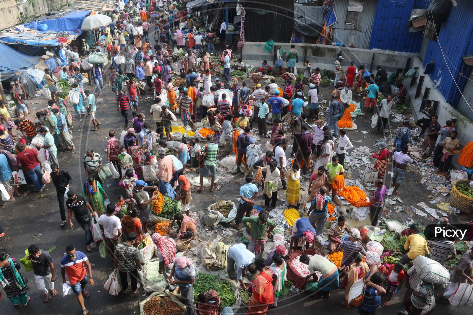 People throng the Mullik Ghat Flower Market flower market as they flout the social distancing norms in Kolkata, August 12, 2020.