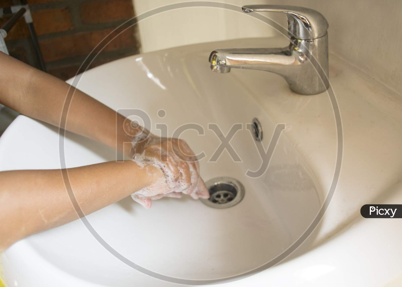 Washing Hands With Foamy Hand Soap Up To The Arm Over The Sink