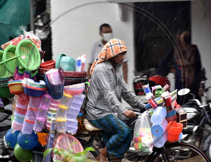 A vendor cycles on the road during heavy rain in Prayagraj, August 12, 2020.