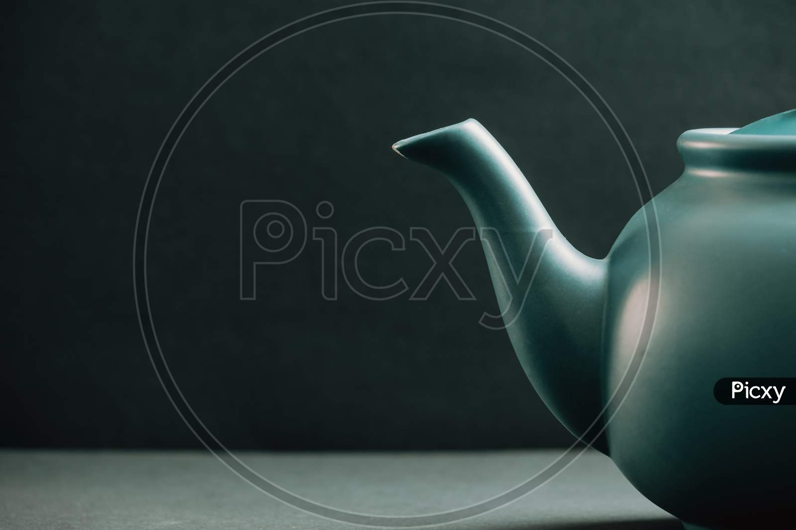 Teapot Showing From The Right Corner Over A Dark Background