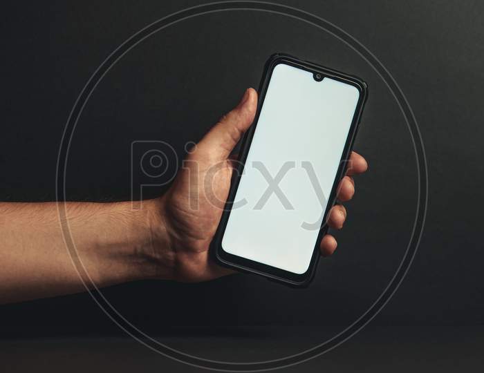 Young Hand Holding A Phone With A White Screen