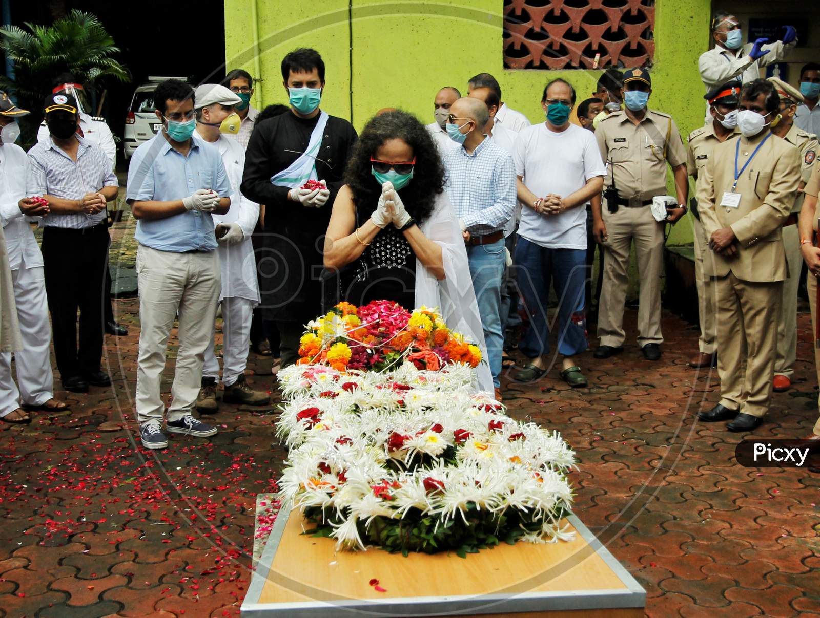 Wife of deceased Air India pilot Deepak Sathe pays him respect during his funeral in Mumbai, India on August 11, 2020.