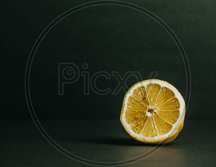 Half Of A Lemon With A Dark Green Background
