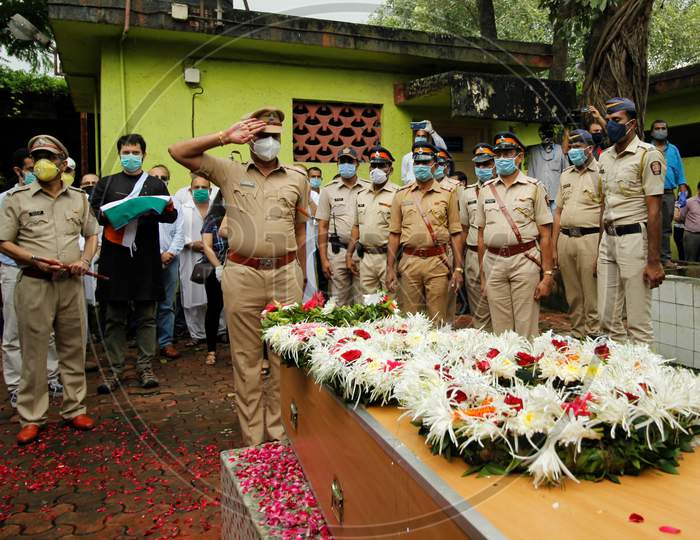 A police personnel salutes the coffin of deceased Air India pilot Deepak Sathe during his funeral in Mumbai, India on August 11, 2020.
