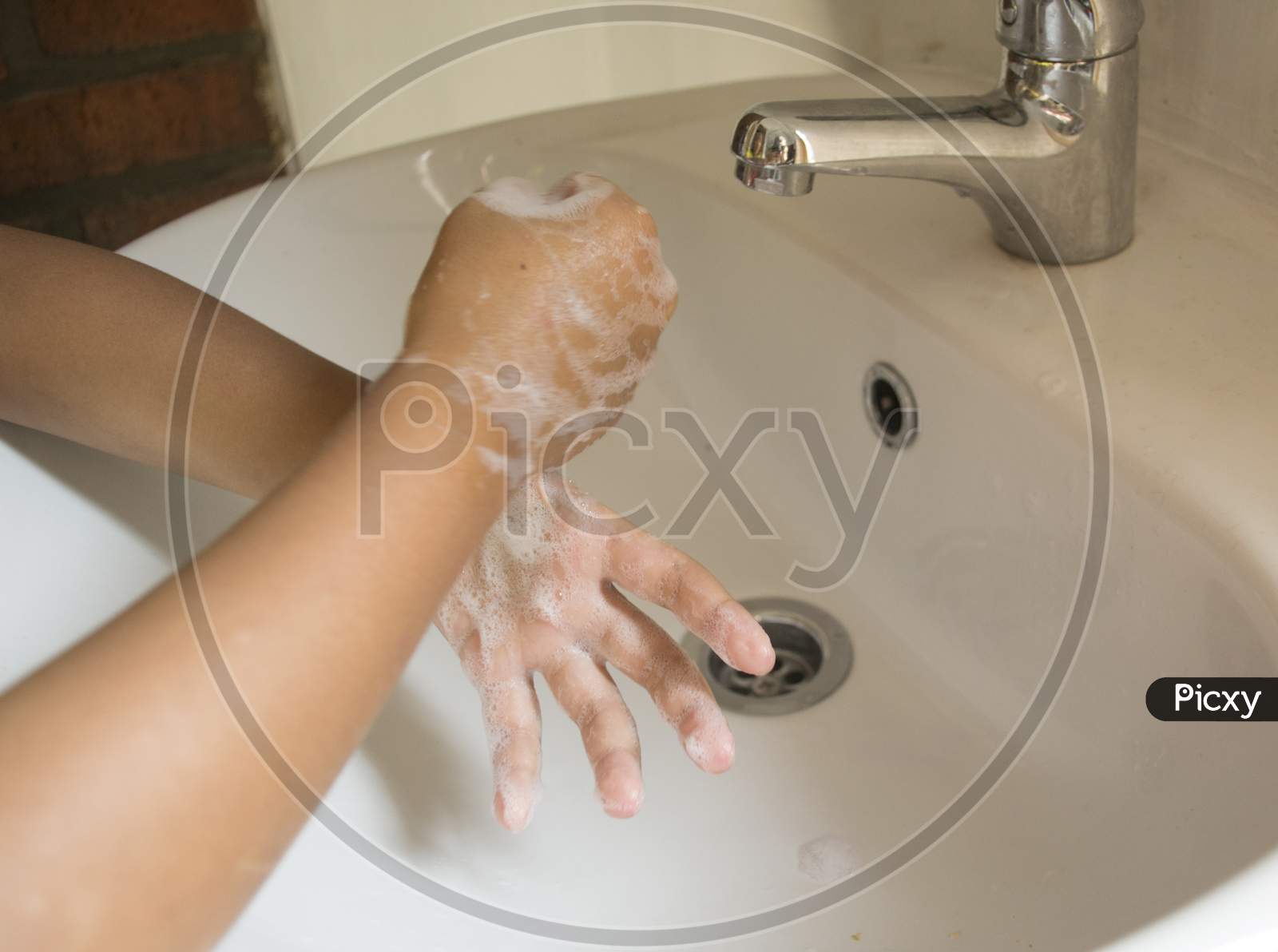 Washing Hands With Foamy Hand Soap By Twist Rubbing Thumbs Over The Sink