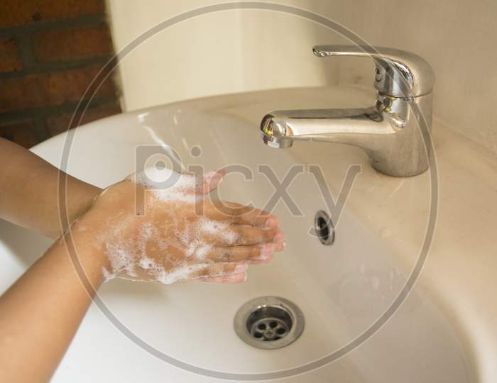 Washing Hands With Hand Soap By Cupped Hands Together Rubbing To Foaming Over The Sink