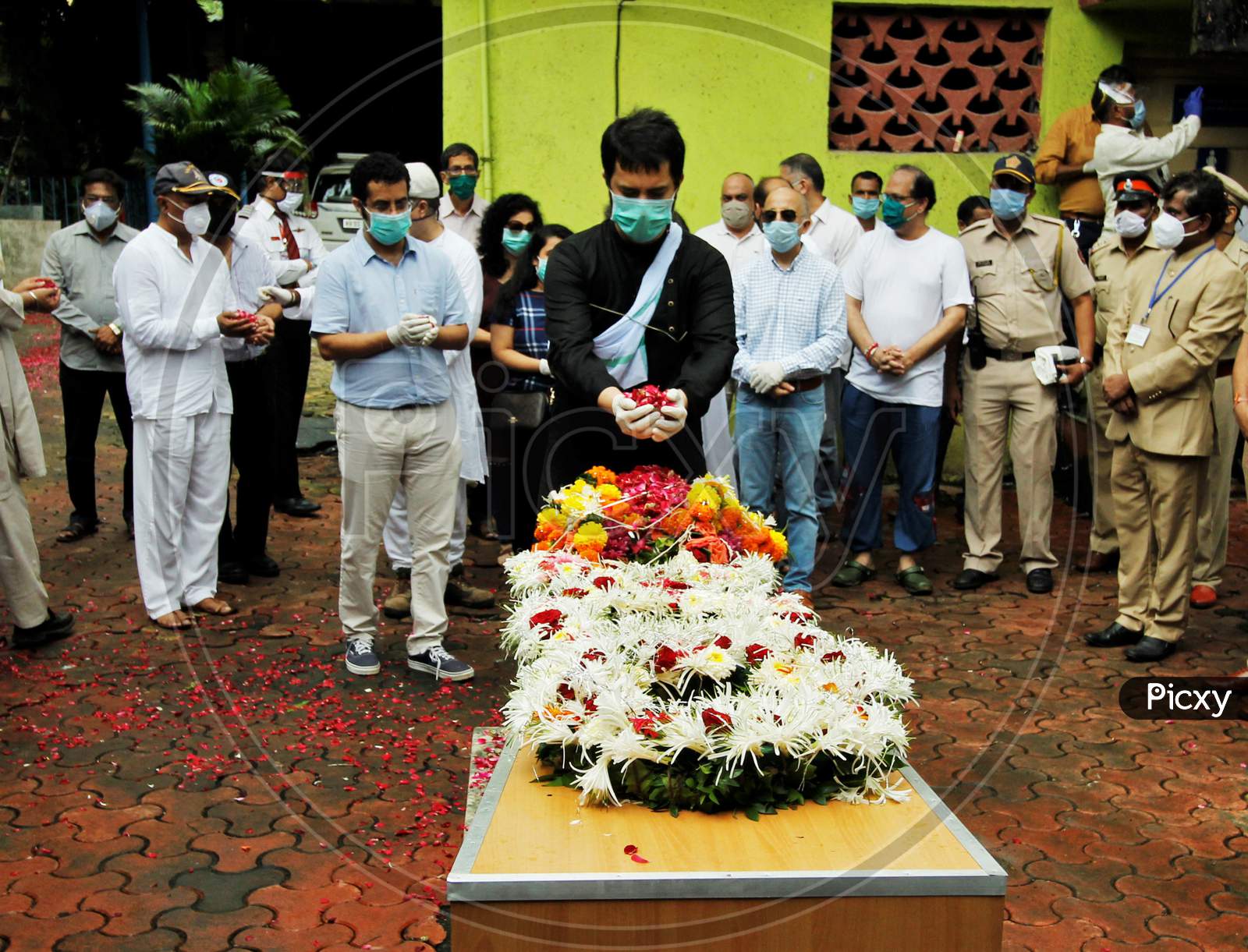 Son of deceased Air India pilot Deepak Sathe places flowers on his coffin during his funeral in Mumbai, India on August 11, 2020.