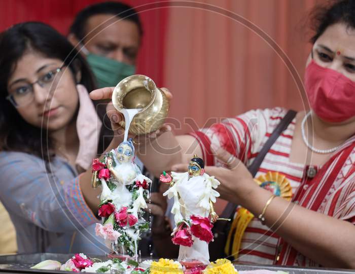 Hindu Devotees Pour Milk Onto The Idol Of Hindu God Lord Krishna On The Occasion Of The 'Janmashtami' Festival Celebrations Marking Krishna's Birth, At ISKCON Temple In New Delhi On August 12, 2020