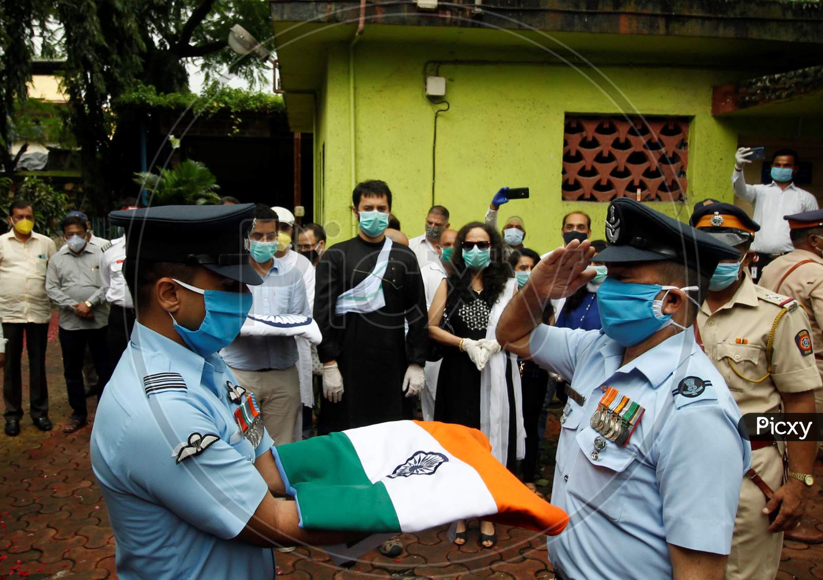 Naval staff pay respect to deceased Air India pilot Deepak Sathe, as family members look on during his funeral in Mumbai, India on August 11, 2020.