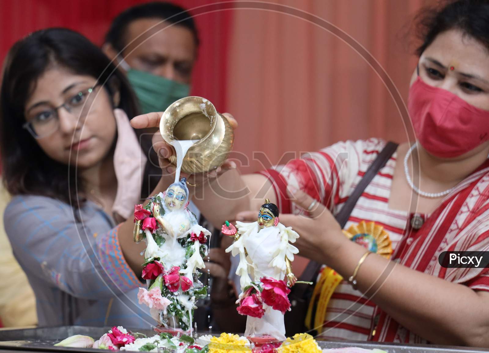 Hindu Devotees Pour Milk Onto The Idol Of Hindu God Lord Krishna On The Occasion Of The 'Janmashtami' Festival Celebrations Marking Krishna's Birth, At ISKCON Temple In New Delhi On August 12, 2020
