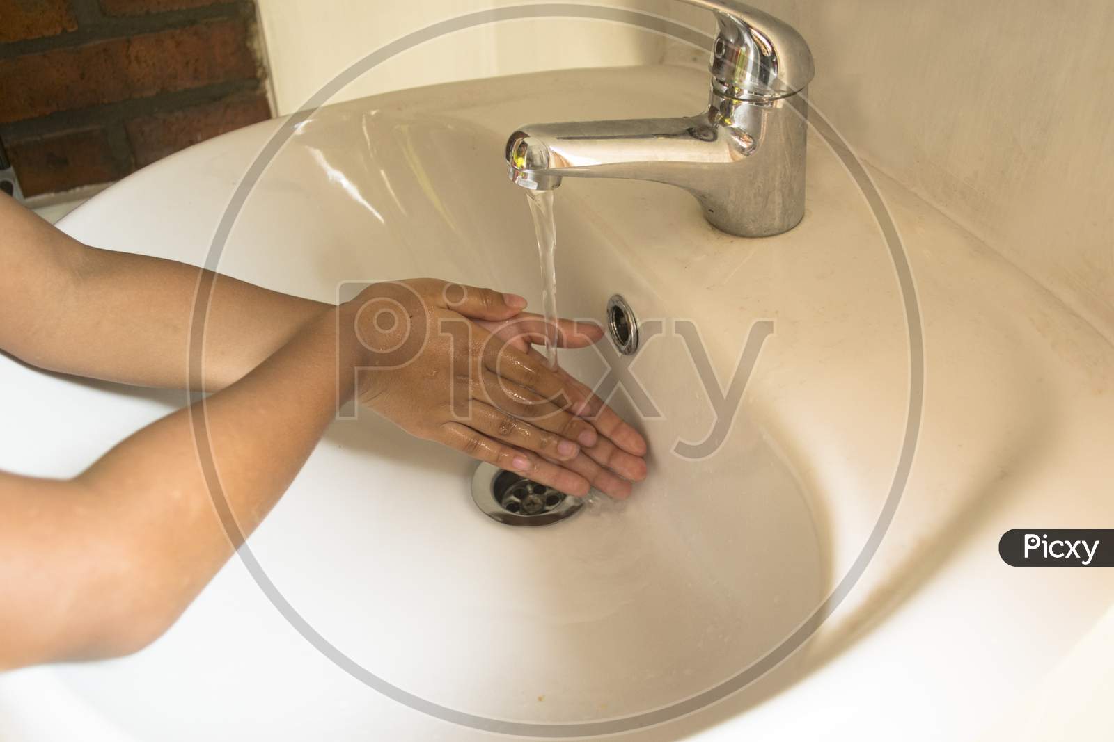 Wet Hands With Water Before Washing Hands With Hand Soap In The Sink