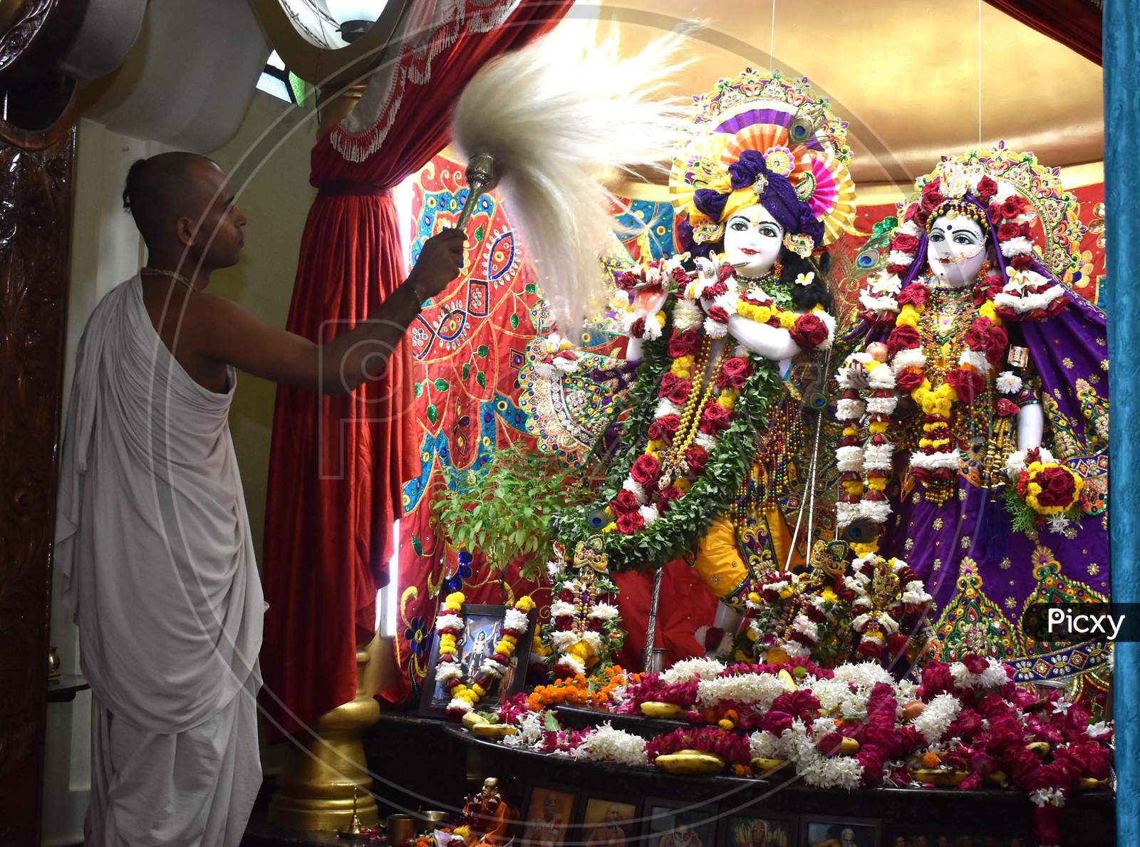 Hindu priest offers prayers to Lord Krishna and Radha on the occasion of Krishna Janmashtami festival at ISKCON temple  in Prayagraj, August 12, 2020.