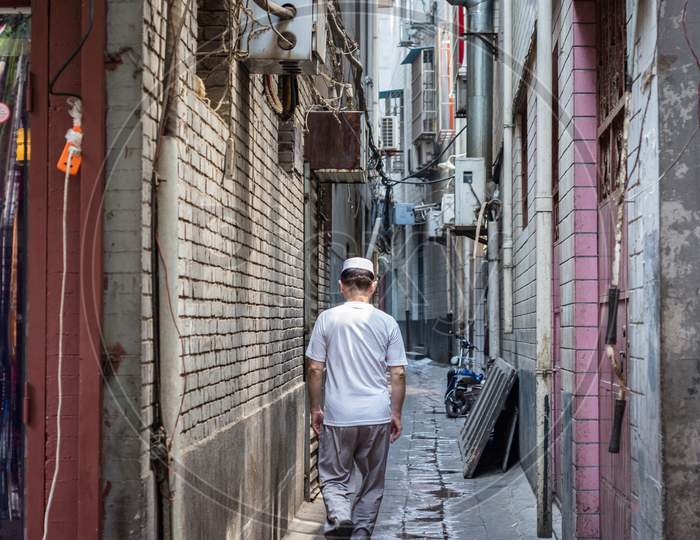 Hui Muslim Ethnic Minority Man Walking Down A Hutong Street In Xian, China