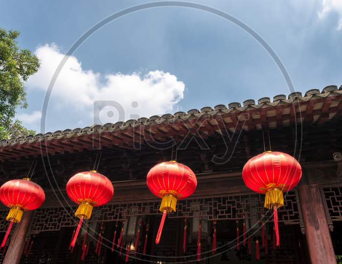 Red Lanterns, Symbols Of Vitality And Good Luck, Hanging From The Roof Of Old Traditional Style Chinese Residence