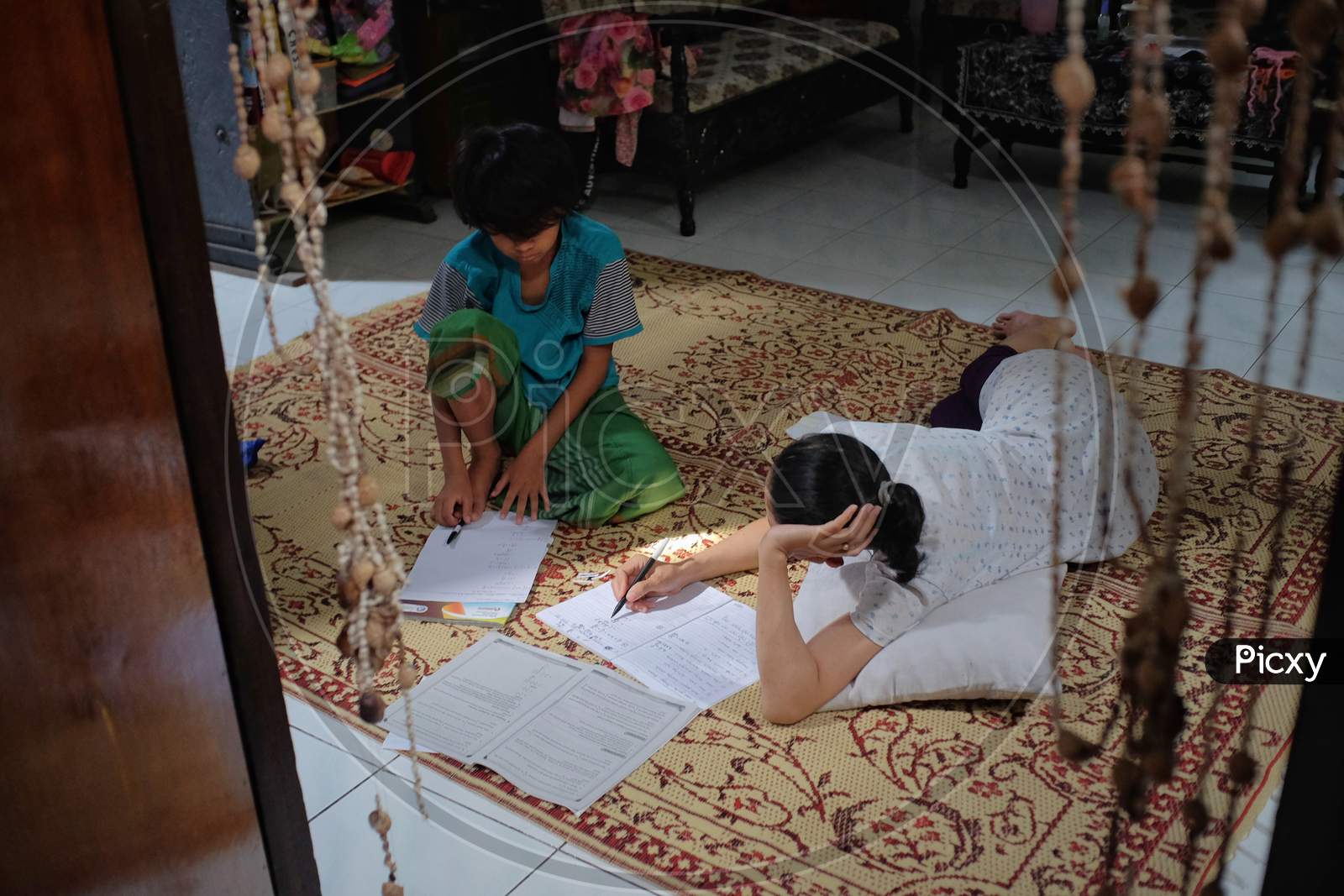 A mother accompanies her child to study at home