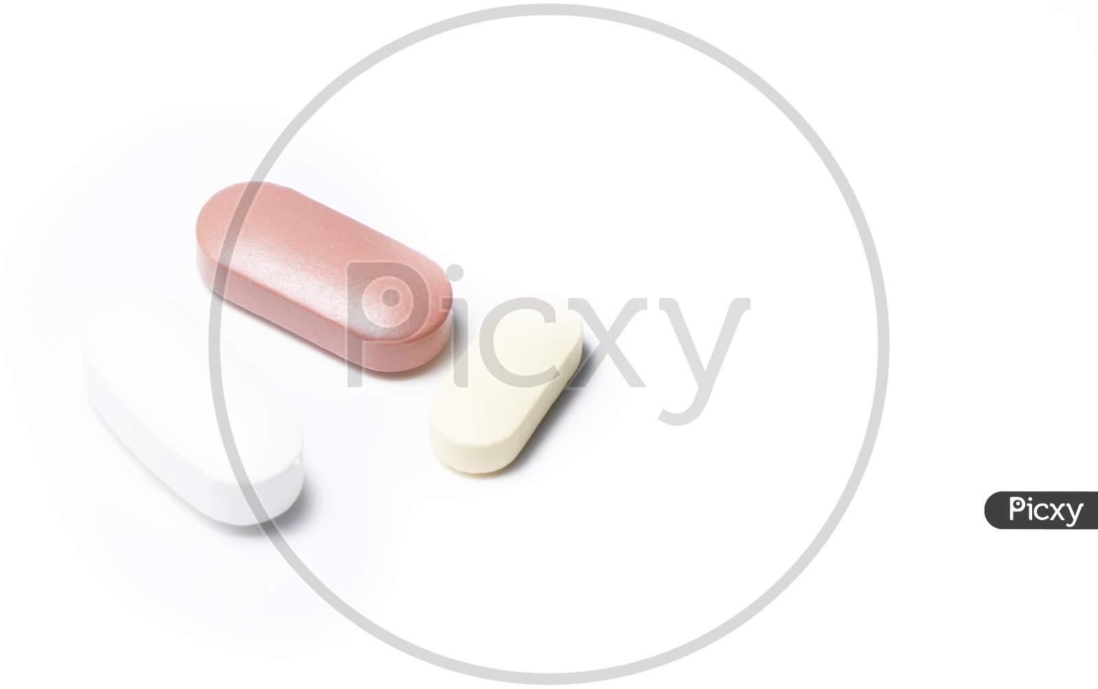 Two brown and one whitish capsule on a white background. With space to write.