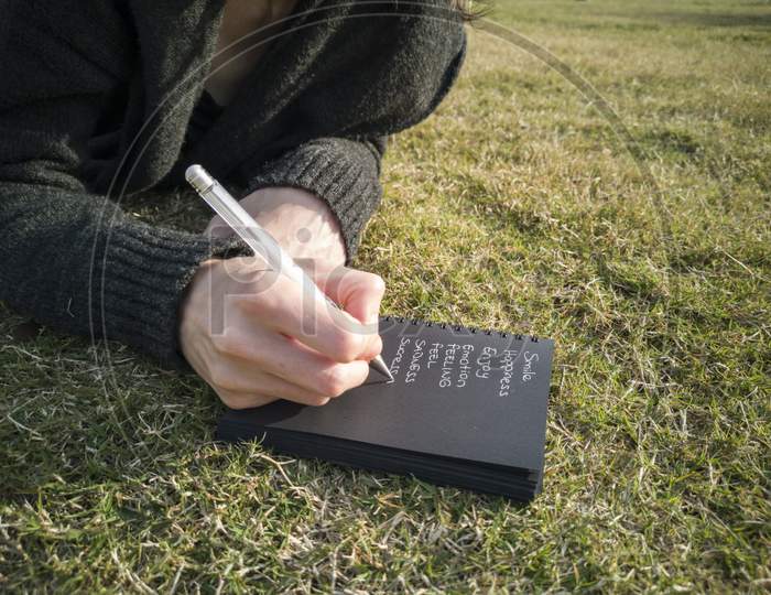 A Man Is Writing Something On Notebook