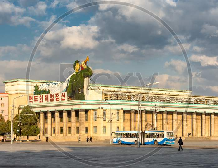 Kim Il-Sung Square And Government Buildings Decorated With Flags And Revolutionary Slogans In Pyongyang, North Korea