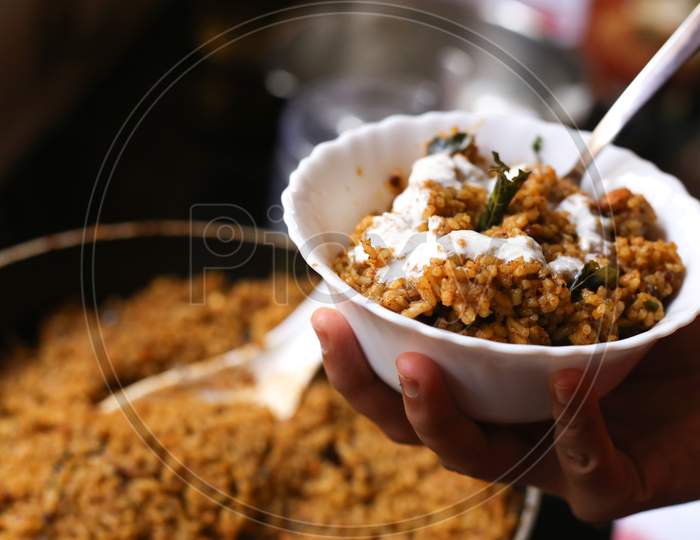 Hand Holding Bowl With Rice With Curd