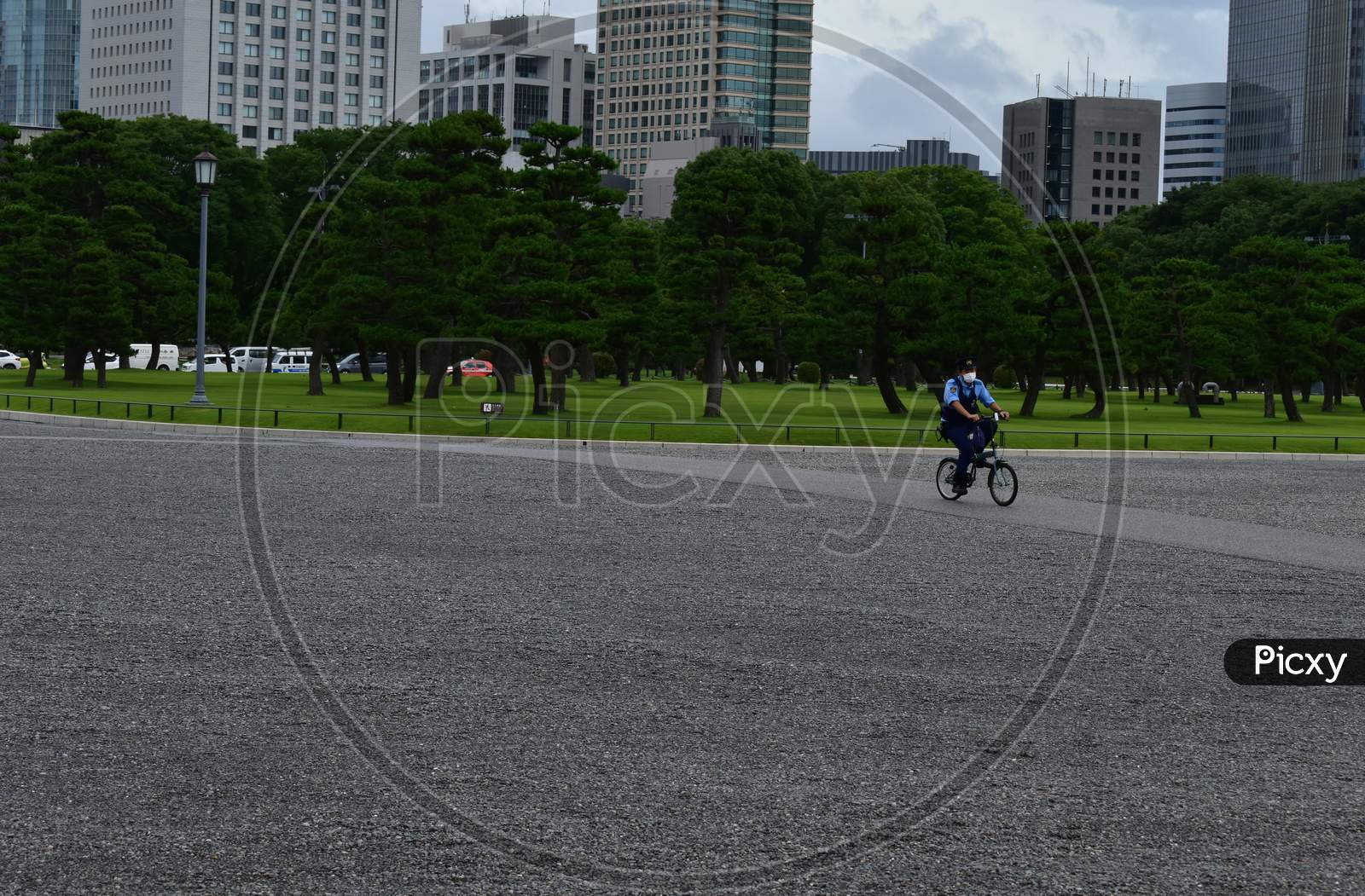 The policeman with a mask circulating alone in the empty imperial palace front garden in Tokyo Japan