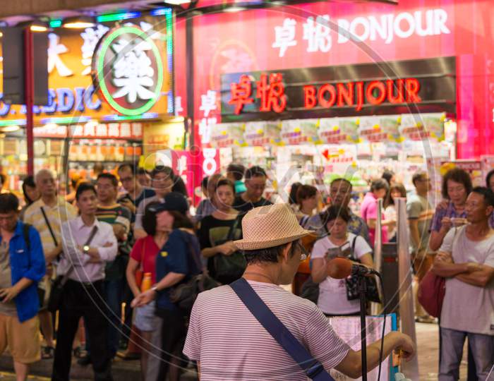 Crowd Listening To Street Musician Performing In Kowloon, Hong Kong