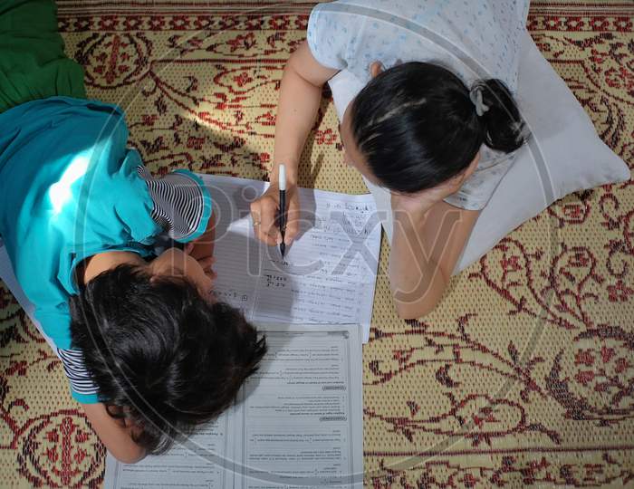 A mother accompanies her child to study at home