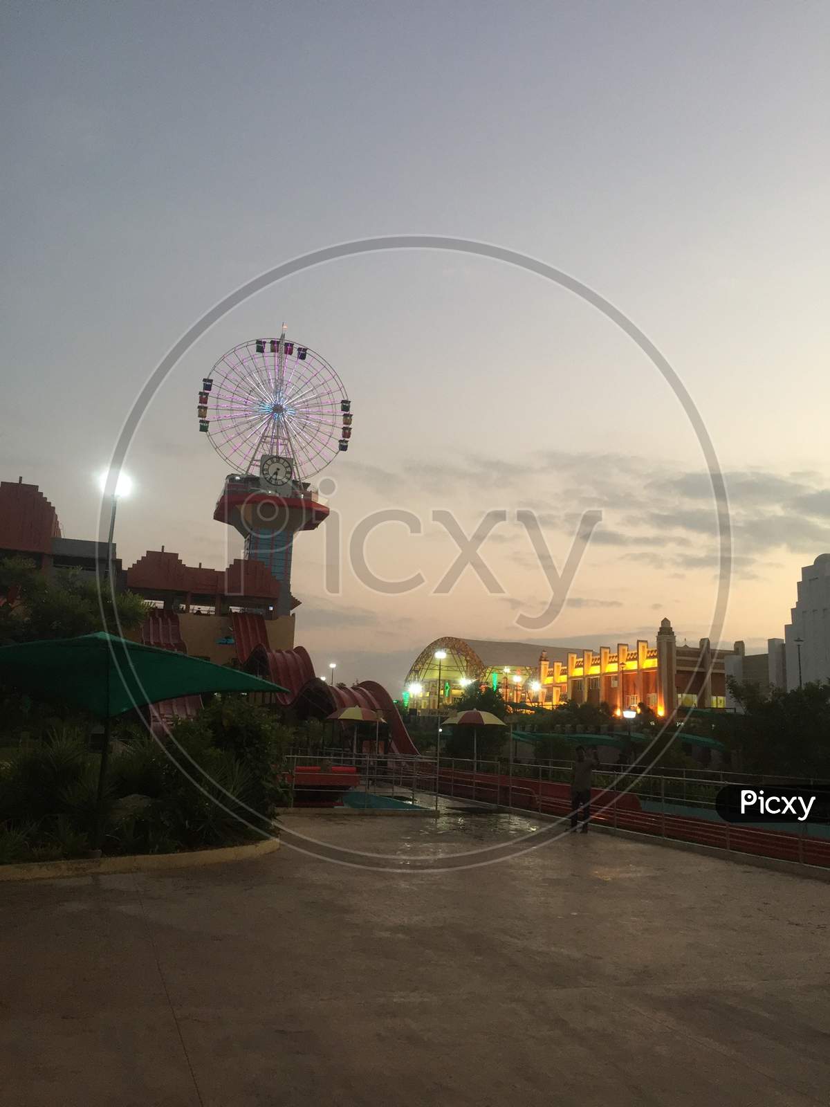 I am evening view of an amusement park With the lights on