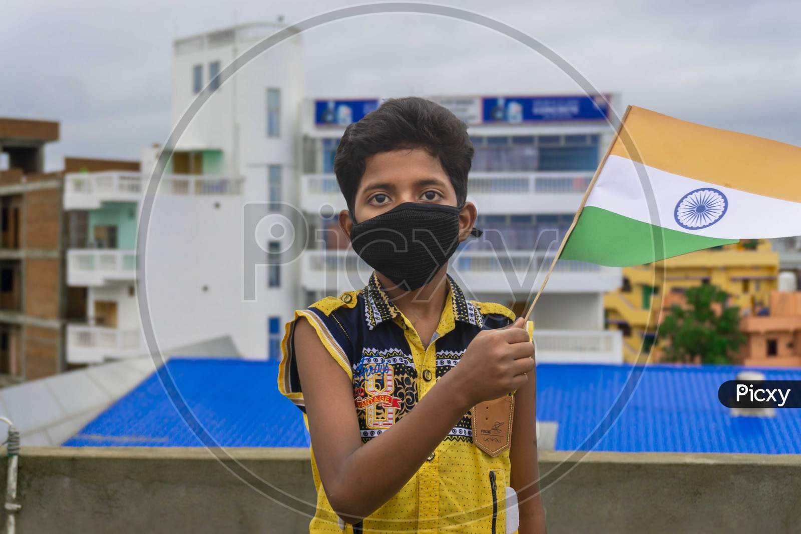 KID WEARING MASK AND HOLDING INDIAN FLAG