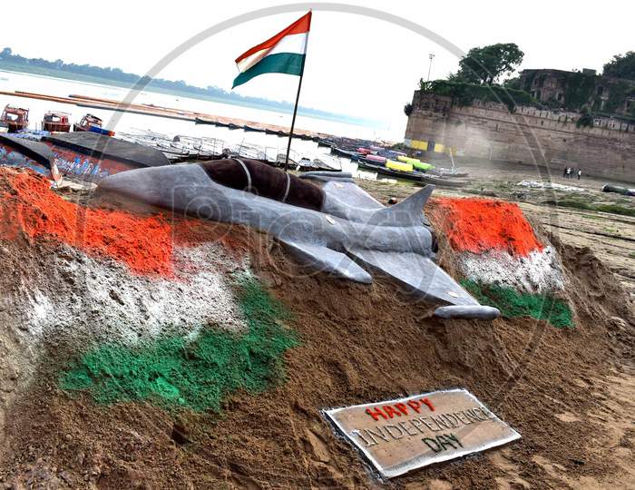 Students make sand art of  tri color national flags ahead of Independence day celebration on the river bank of Yamuna in Prayagraj, August 14, 2020.