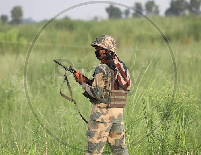 Border Security Force (BSF) troops patrol near flooded Basantar River along the international border ahead of the Independence Day, in Samba district of Jammu on August 13, 2020.