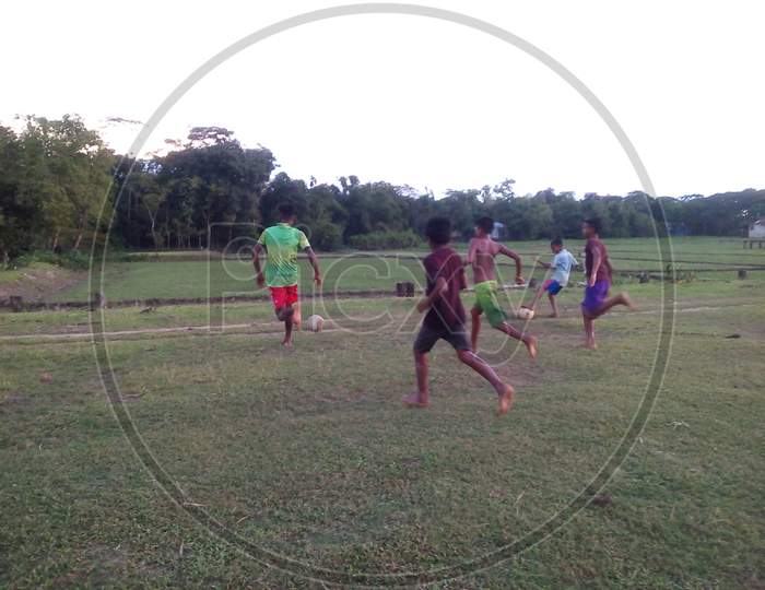 Rural boys playing football  in the field