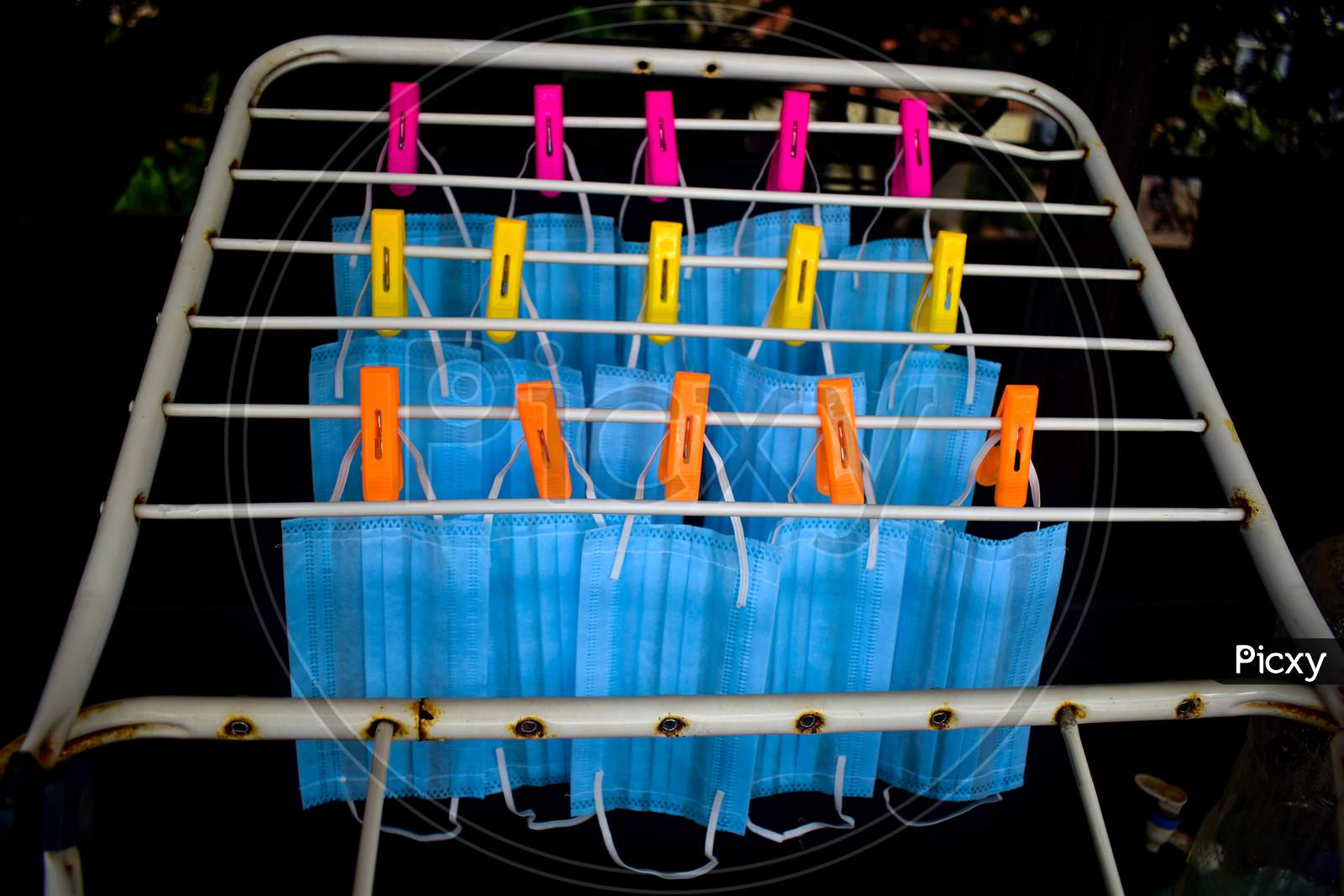 Corona Virus Pandemic Masks Being Hanged On A Cloth Rod After Cleaning. Reusable Blue Colored Face Masks