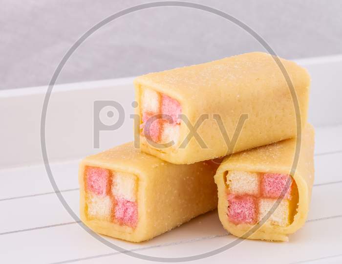 Delicious Mini Battenberg Cake, The Tradional Sweet Afternoon Tea Snack. Pink And Yellow Sponge Cake Covered In Jam Wrapped In Almond Marzipan.