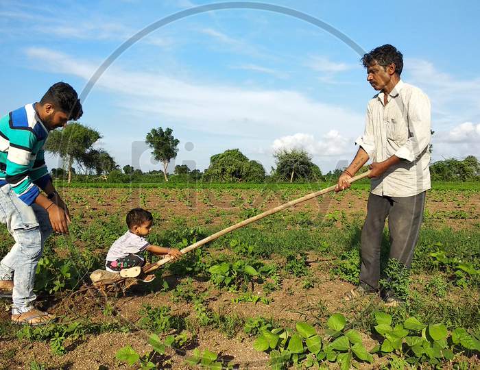 17 july 2020: A young Indian child is having fun on a farm with his grandfather and uncle
