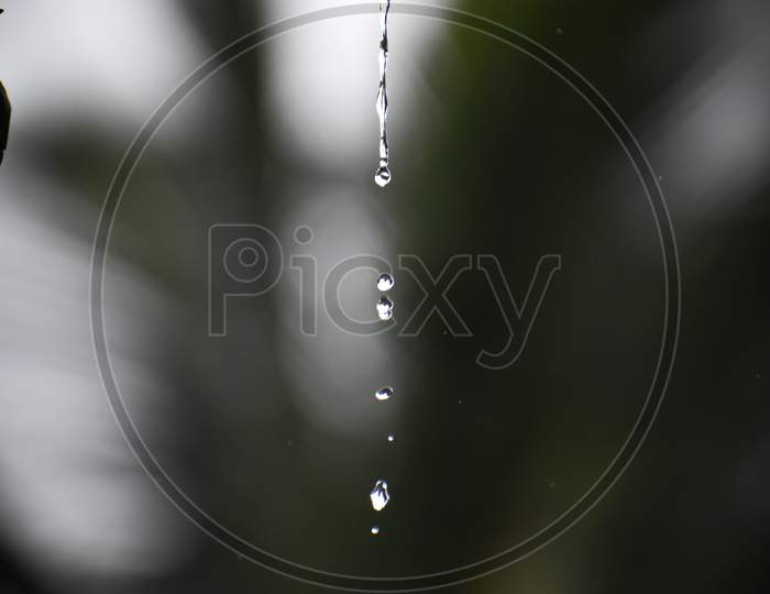 Water drops splashing from the rain water-outlet pipe.