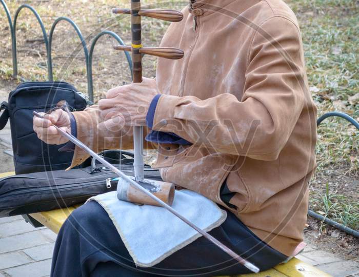Elderly Man Playing Traditional Chinese Instrument At The Temple Of Heaven