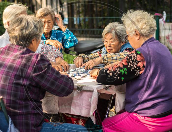 Elderly Women Playing Mahjong Game In The Street In Beijing, China