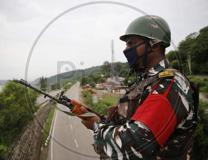 CRPF personnel stand guard along the Jammu-Srinagar highway near Jammu, ahead of the 74th Independence day celebrations  in Jammu on August 14, 2020.