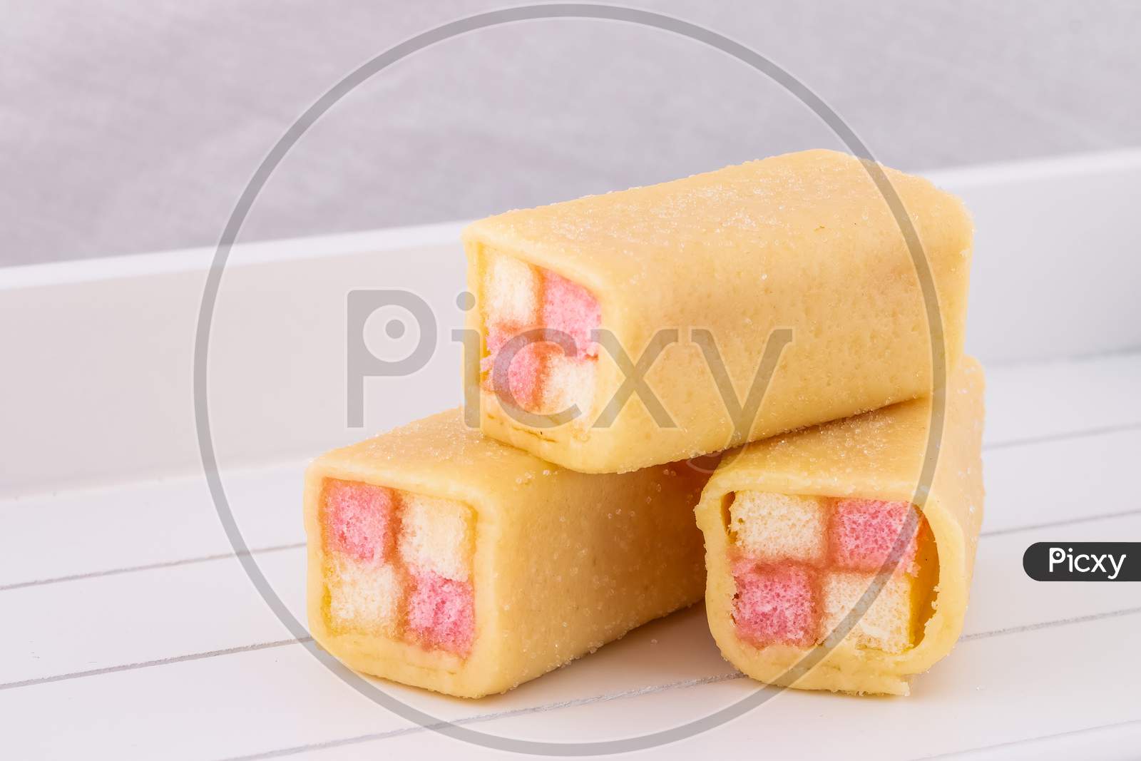 Delicious Mini Battenberg Cake, The Tradional Sweet Afternoon Tea Snack. Pink And Yellow Sponge Cake Covered In Jam Wrapped In Almond Marzipan.