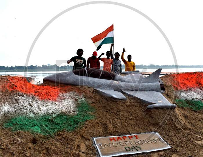 Students make sand art of tri-colored national flags ahead of Independence day celebration on the river bank of Yamuna in Prayagraj, August 14, 2020.