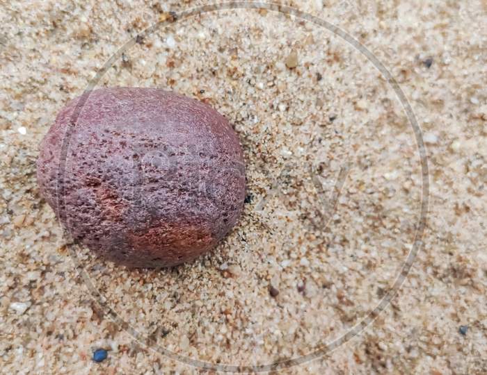 Selective Focus On A Red Stone Middle Of The Sand