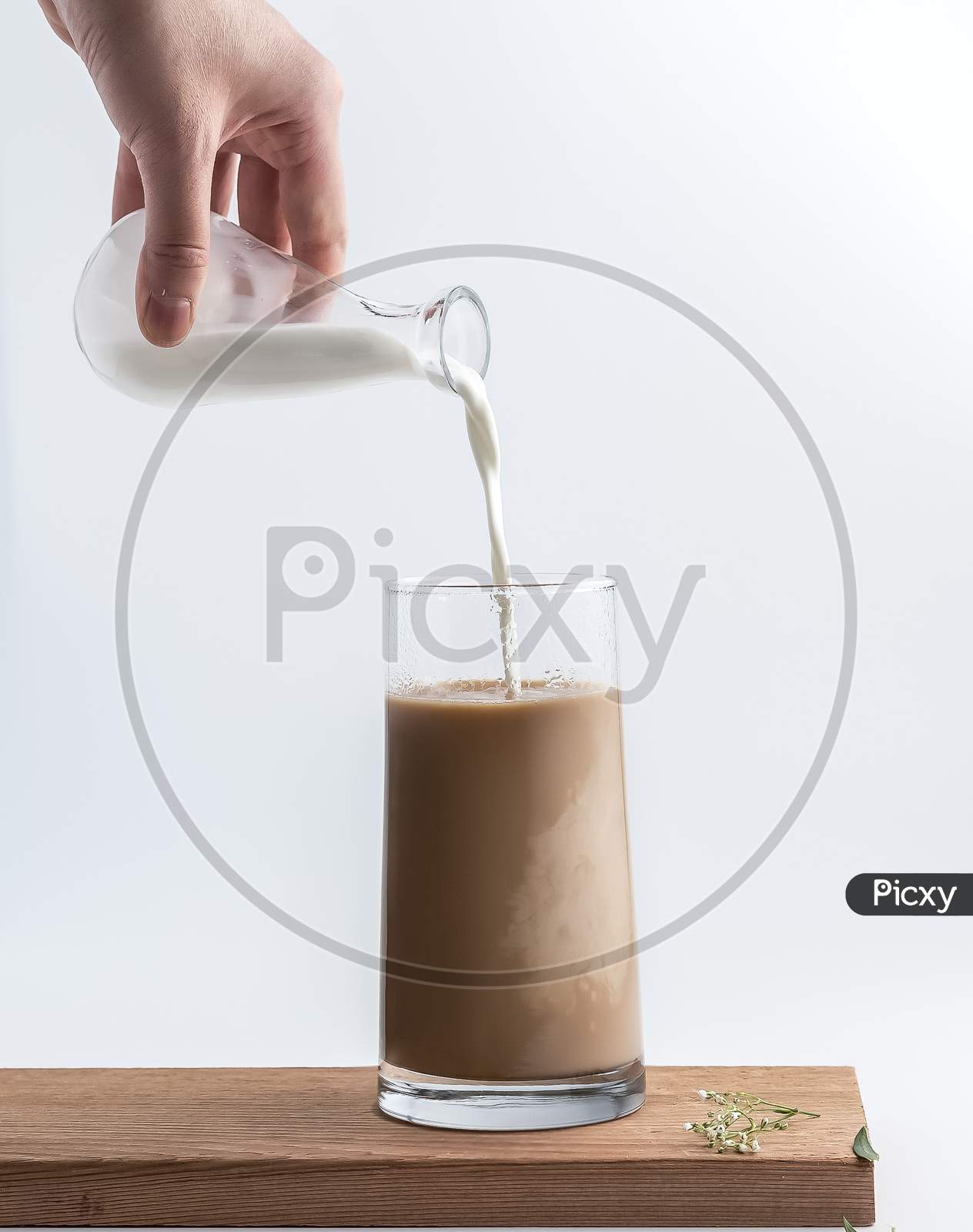 pouring milk into glass on the table