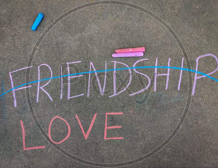 The Inscription Text On The Grey Board, Love And Crossed Out Friendship Inscription.Using Color Chalk Pieces