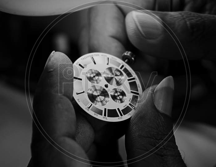 Watchmaker Examining The Dial And Crown Of A Watch