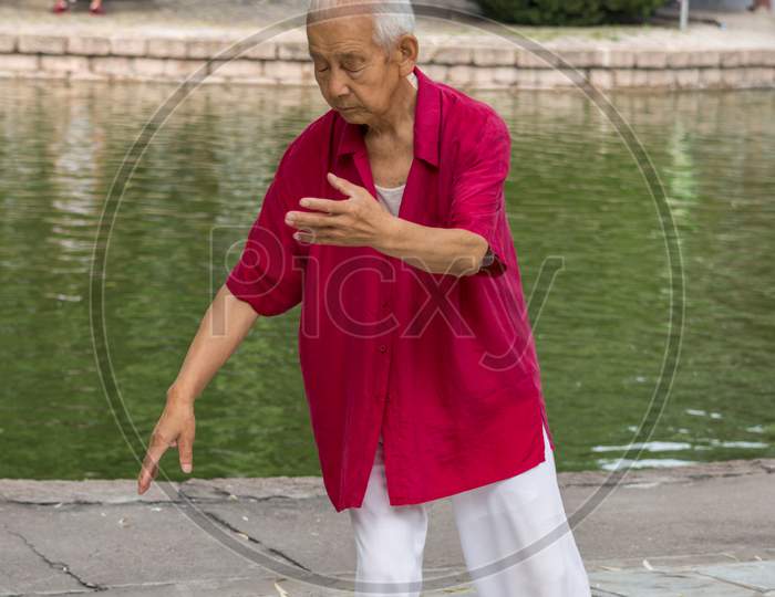 Elderly Man Practicing Tai Chi In Tuanjiehu Park In Beijing, China