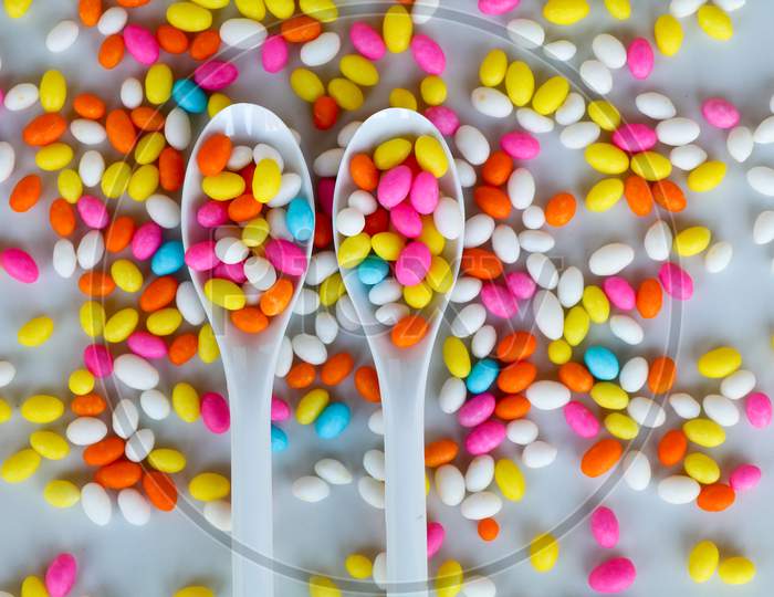 Multi Colored Fennel Sugar Candy In Spoons And Scattered As Background