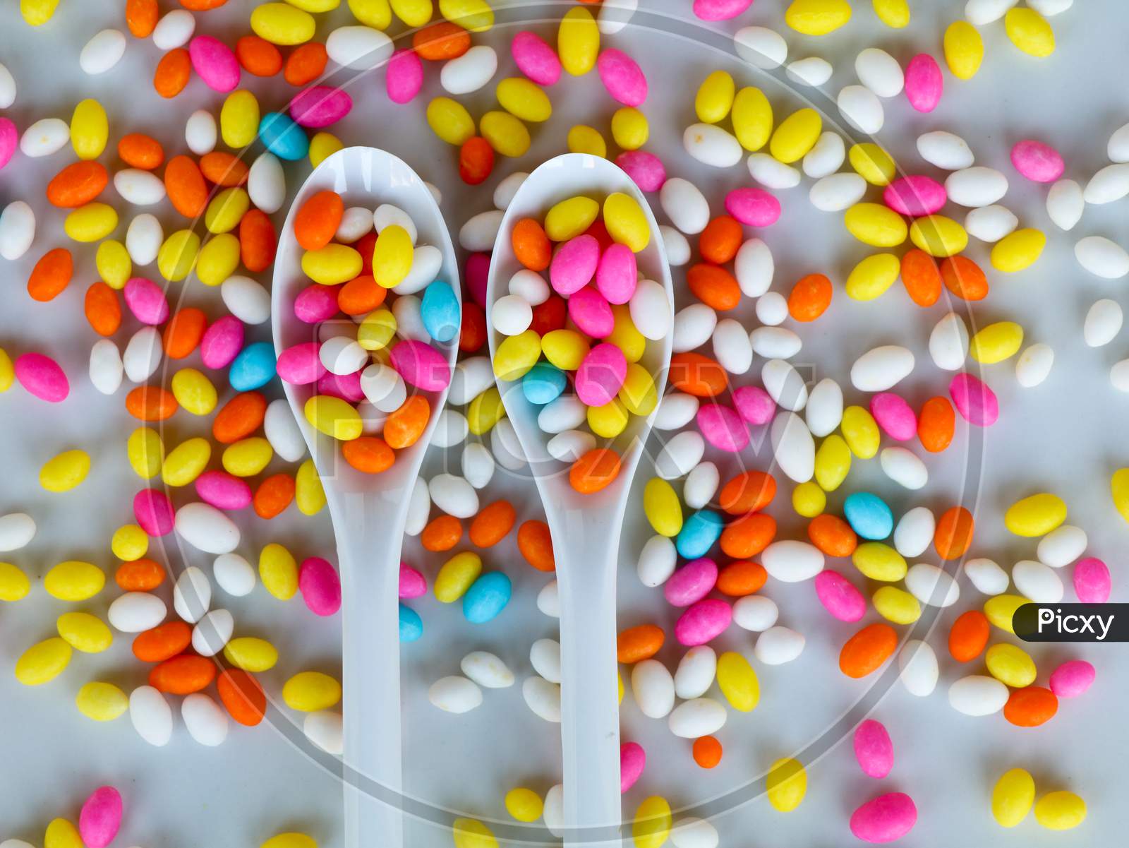 Multi Colored Fennel Sugar Candy In Spoons And Scattered As Background